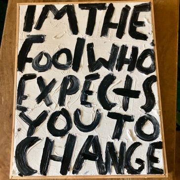 Eric Stefanski's I’m the Fool that Expects you to Change is an oil on canvas text art painting from 2023. It depicts the title in black letters on a white background.
